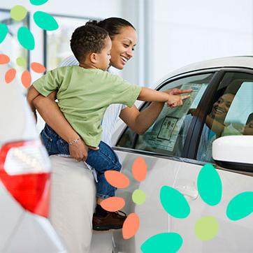 一位抱着孩子的母亲指着一辆汽车的信息表